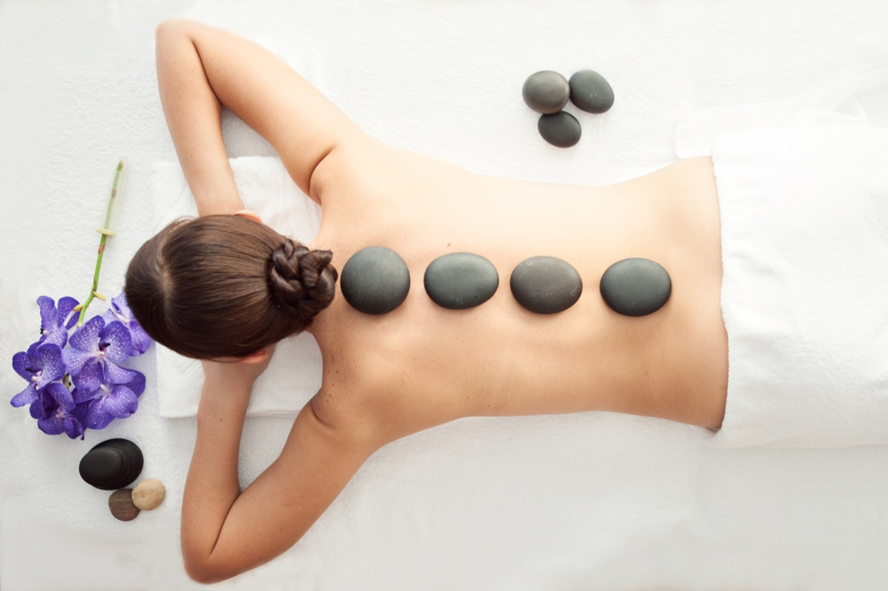 Woman Laying Down and Has Hot Stones on Her Back